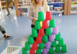 Emilka układa wieże z kubeczków wg kodu